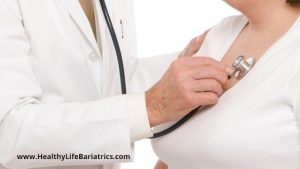 A doctor is examining a woman's chest with a stethoscope.