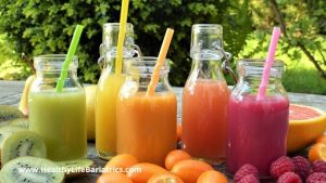 A variety of fruit juices in jars with straws.