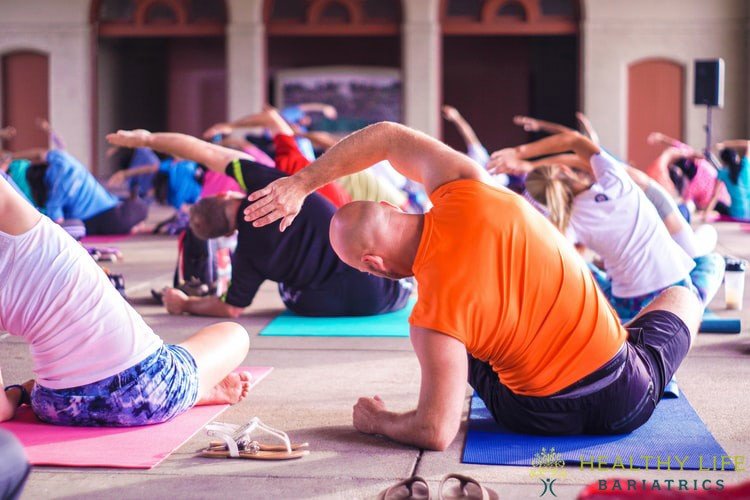 A group of people doing yoga in an outdoor area.