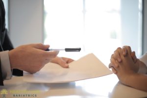 A man is holding a pen and a woman is holding a pen.