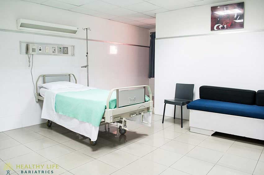 A hospital room with a bed and a couch.