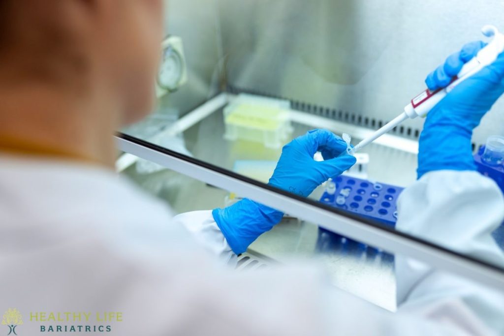 A person in a lab coat holding a test tube.