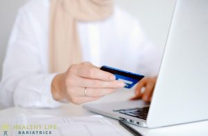 A woman using a credit card on a laptop.