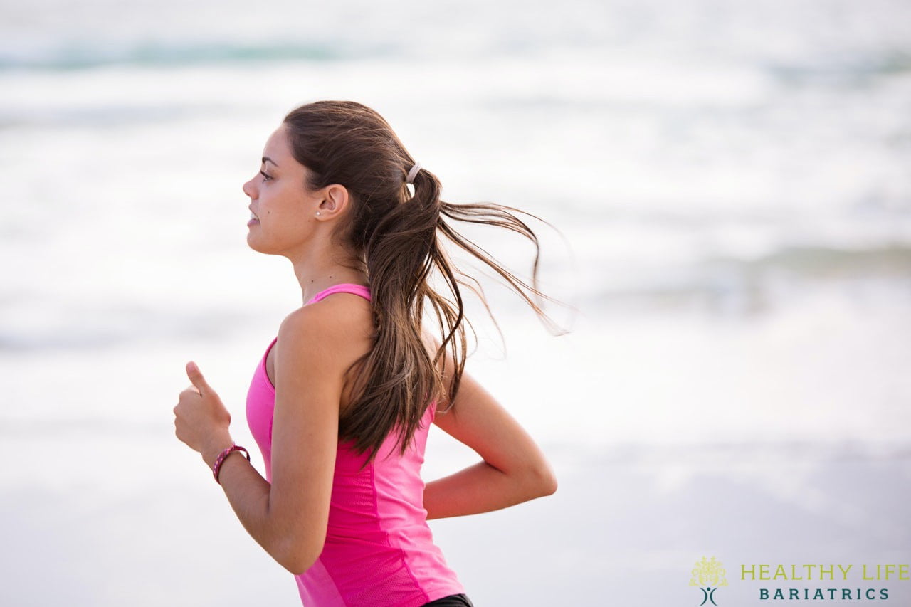 A woman jogging on the beach.