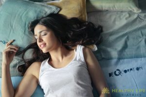 A woman laying on a bed with pillows.