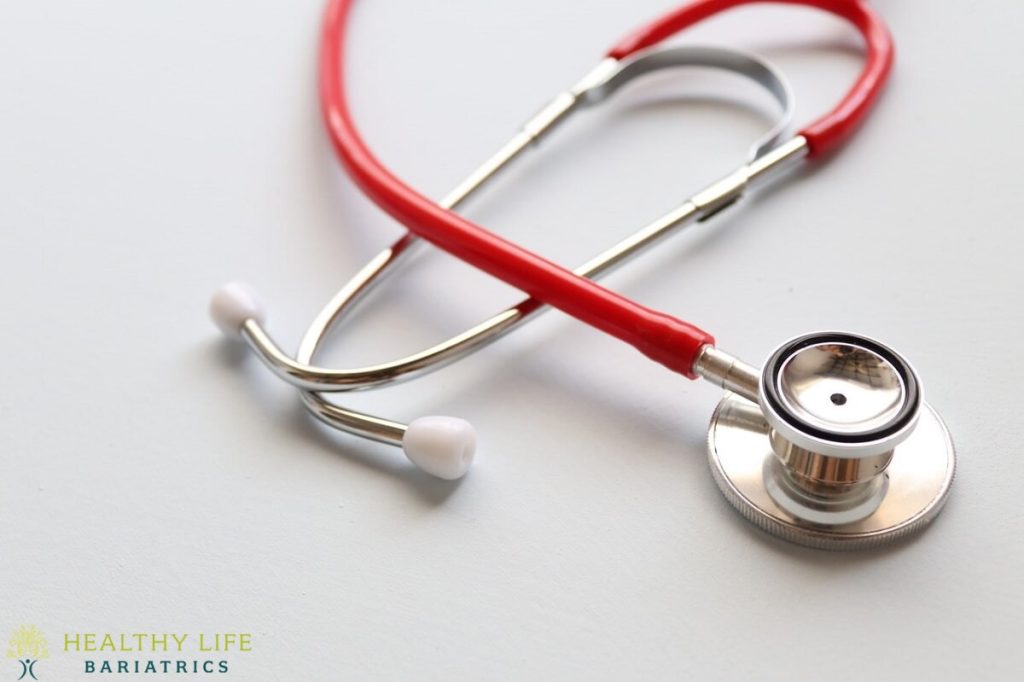 A red stethoscope on a white background.