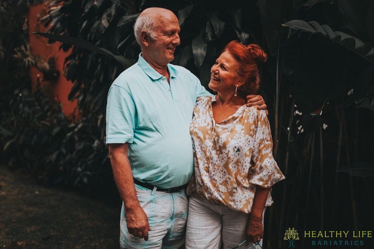 An older couple posing for a photo with the words healthy life.