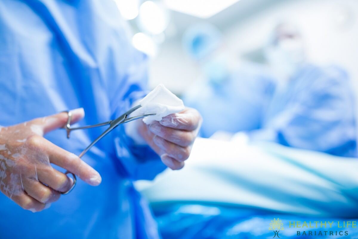 A surgeon holding a pair of scissors in an operating room.