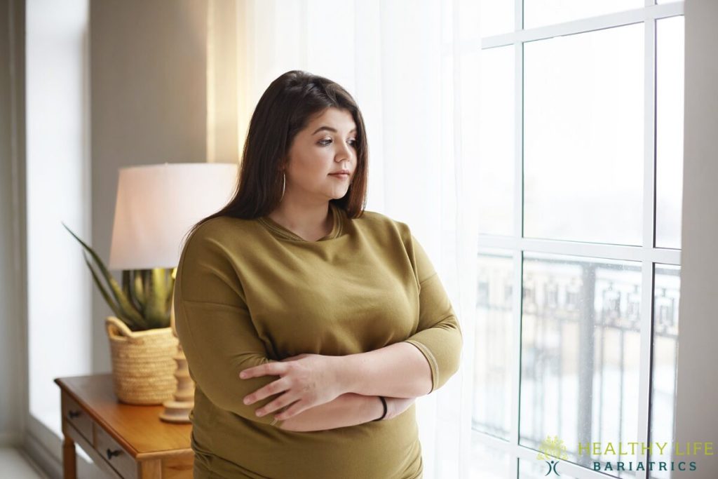 A woman standing in front of a window.