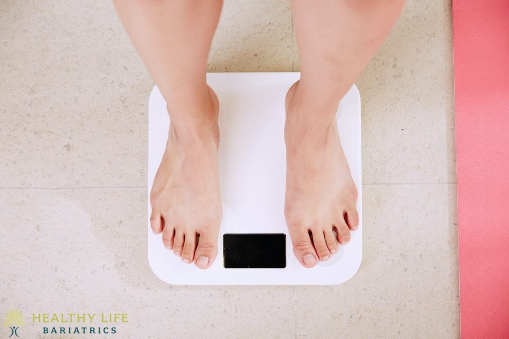 A woman's feet standing on a digital scale.