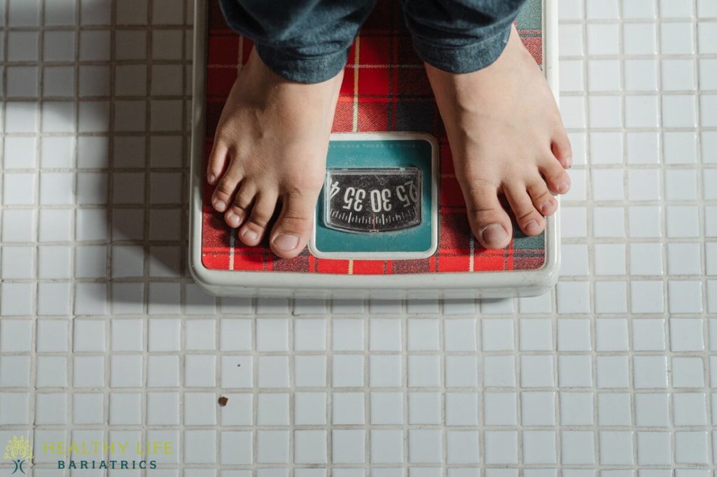 A person's feet standing on a bathroom scale.