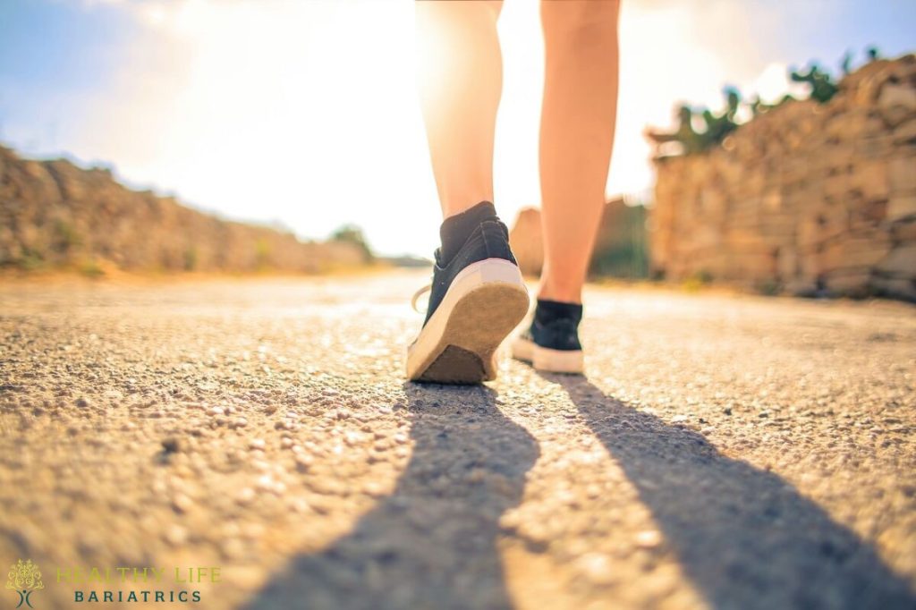 A woman walking down a road with her shoes on.