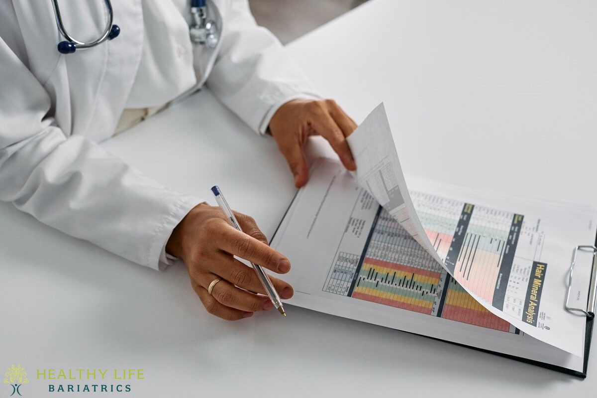 A doctor in a white coat is looking at a clipboard.