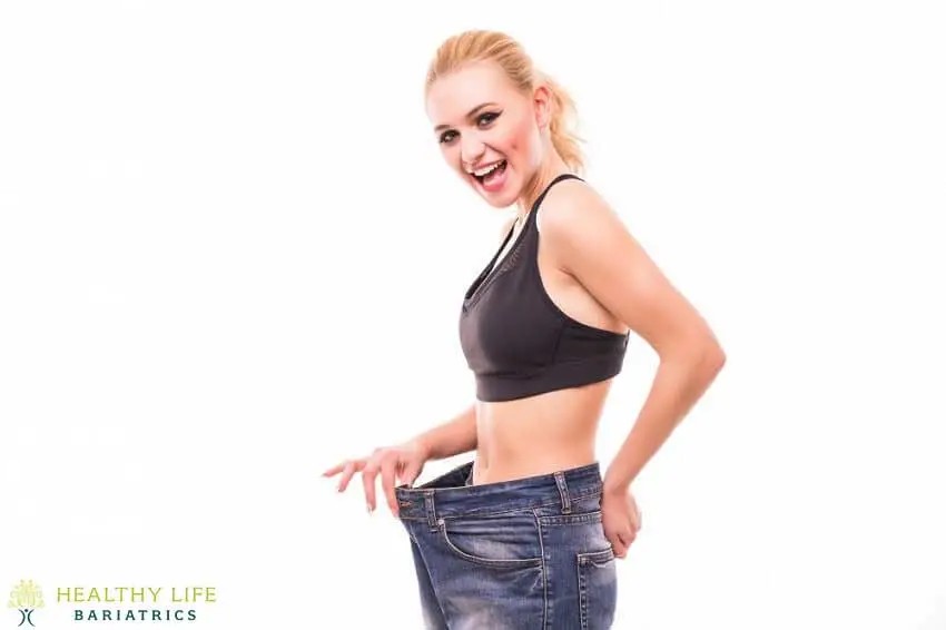 A woman posing with her jeans on a white background.