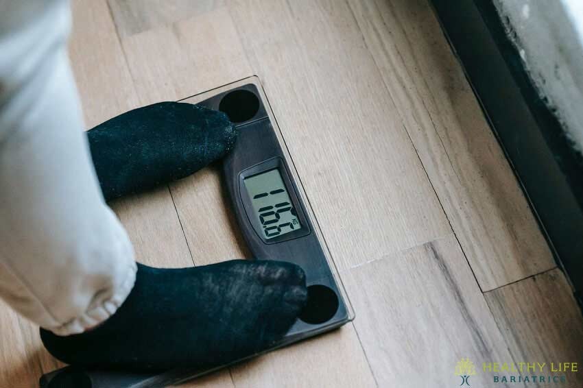 A person's feet standing on a digital scale.