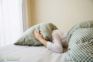 A woman laying on a bed with pillows under her head.