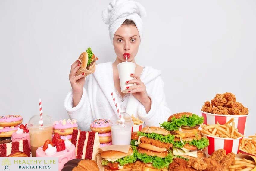 A woman in a bathrobe holding up a plate of food.