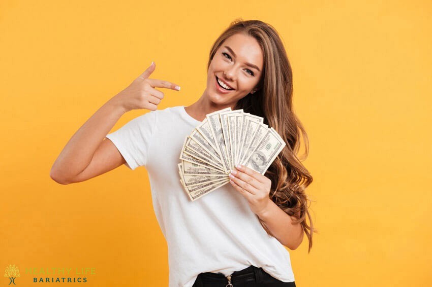 A woman holding a stack of money and pointing to the camera.