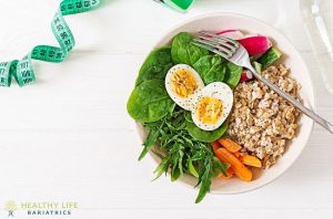 A bowl of food with eggs, vegetables and a measuring tape.