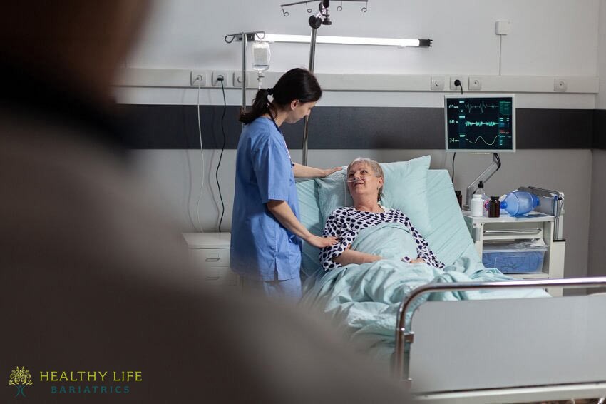 A nurse is helping a patient in a hospital bed.