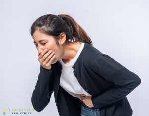 A woman with her hands on her stomach.