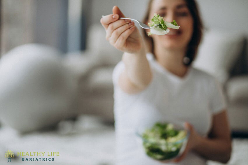 A woman is holding a bowl of salad.