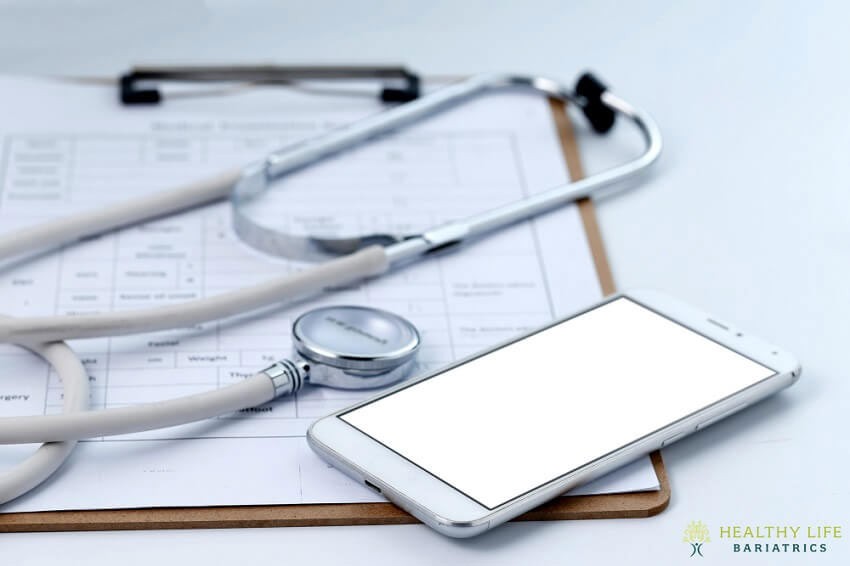 A smartphone and a stethoscope on top of a sheet of paper.