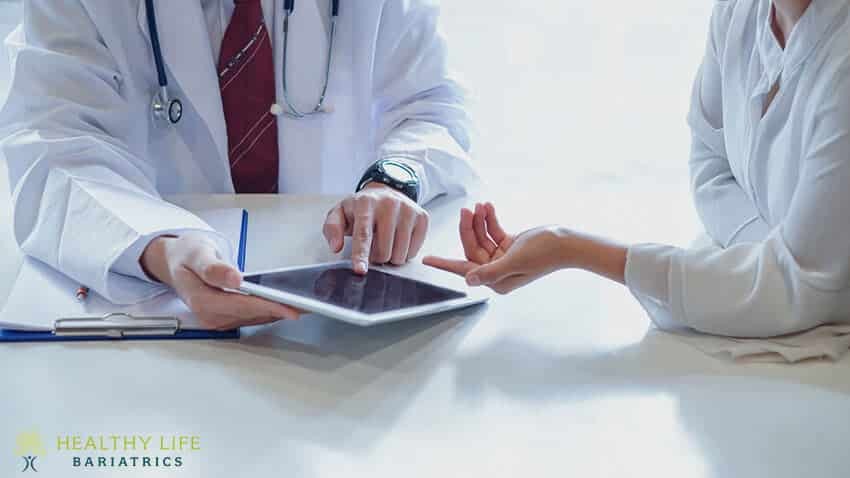 A woman and a man are talking to a doctor on a tablet.