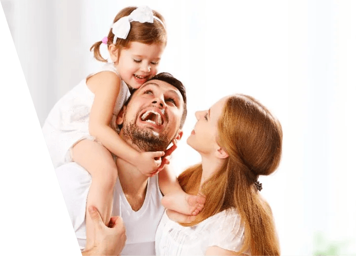 A joyful family moment with a father, who had weight loss surgery in Los Angeles, carrying his young daughter on his shoulders while both parents smile up at her.